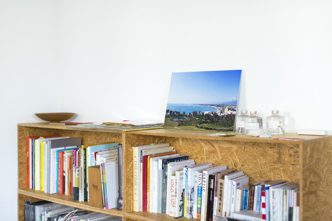 本棚の上に飾られた、海辺の景色が美しいWALL DECOR