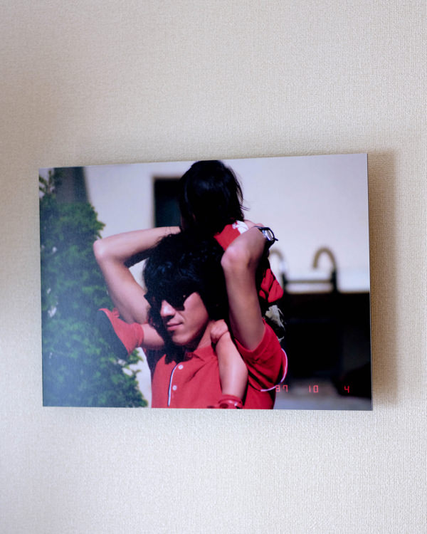 白い壁に飾られた、子供を肩車する男性の写真のWALL DECOR。