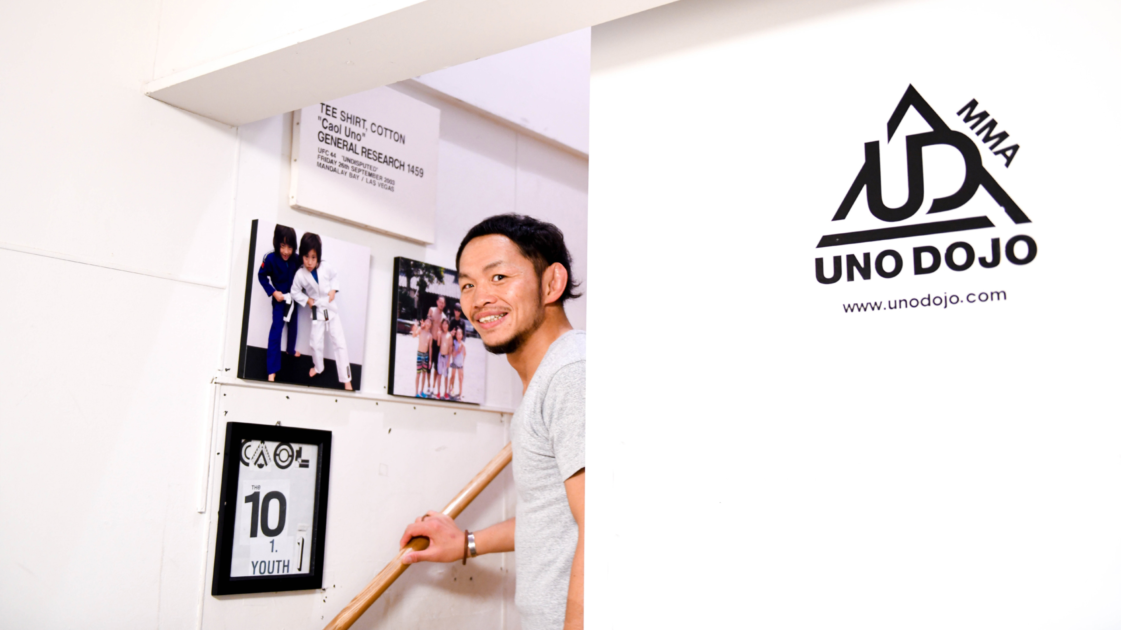男性のポートレートと、室内に飾られた写真や「UNIT DOJO」のロゴを組み合わせた、インタビュー記事のトップ画像。
