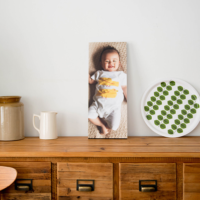 白いジャグやトレイとともに棚に飾られた、赤ちゃんの写真のWALL DECOR カジュアル