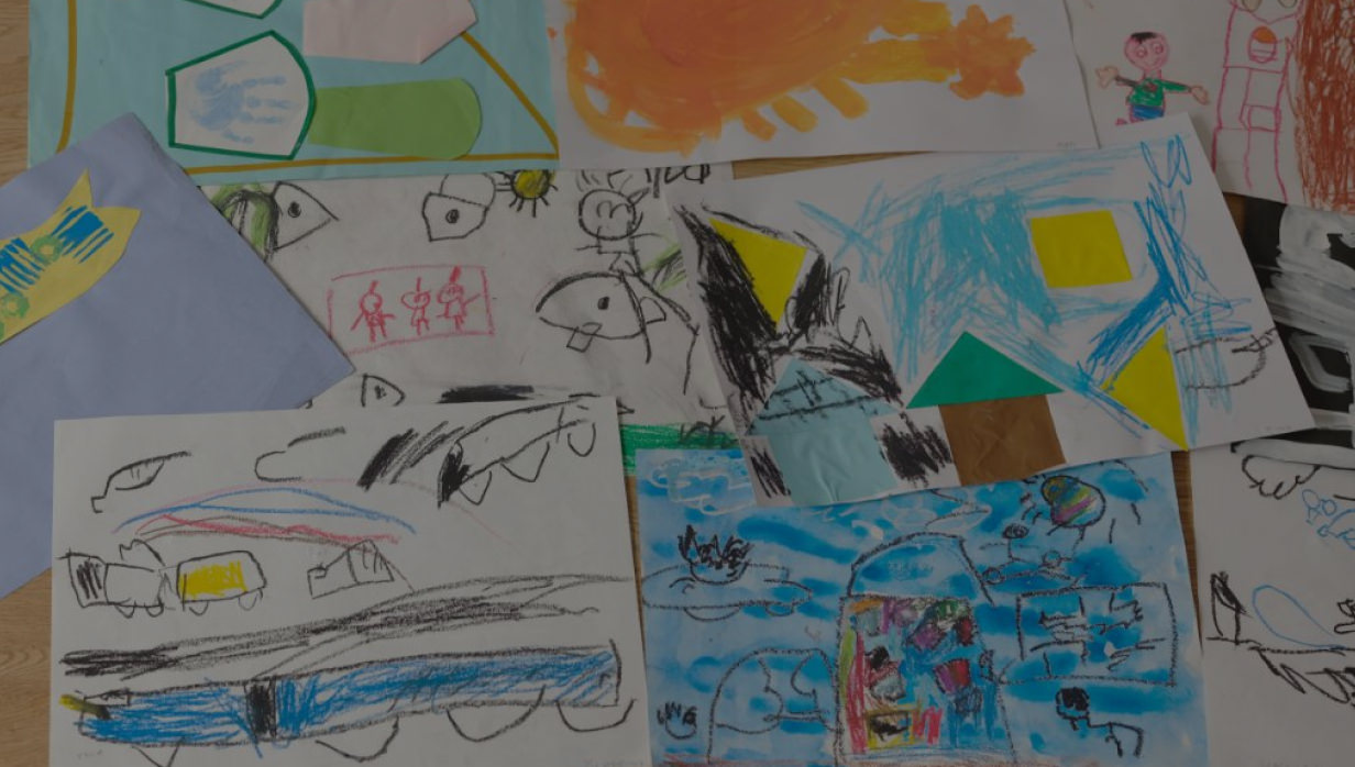 子供たちが描いた色とりどりの絵が、机いっぱいに広がる様子