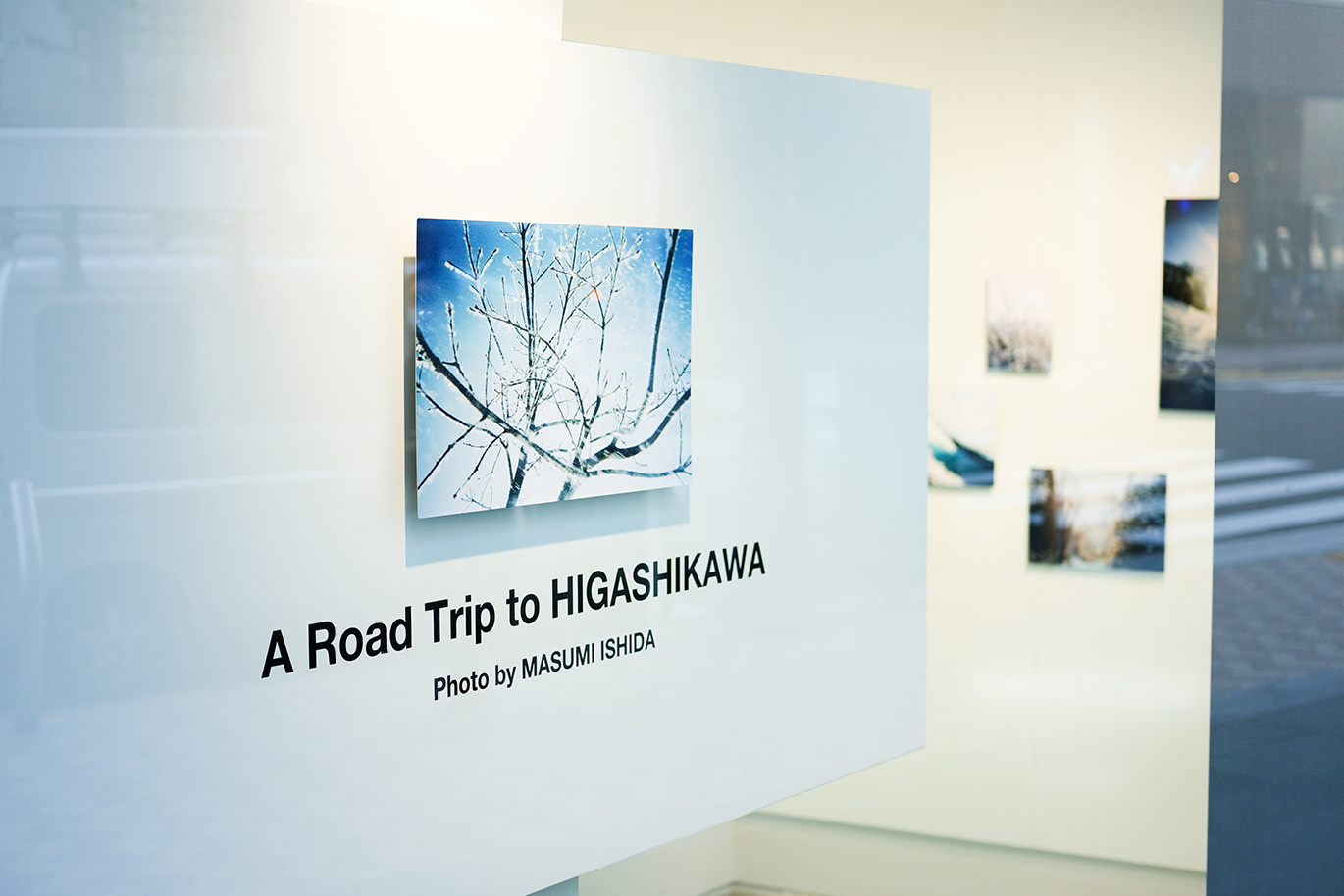 白壁に書かれた英語のタイトルと、雪景色の写真が並ぶ展示