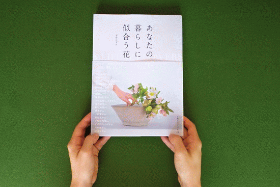 フォトブックのページをめくり、色鮮やかな花々の写真を楽しむ様子。