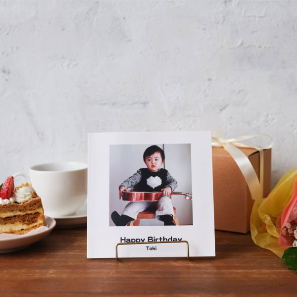 ケーキやプレゼントと一緒に飾られた、子どもの写真が表紙のフォトブック。
