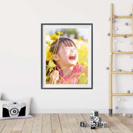 笑顔の子どもと花の写真を飾った部屋