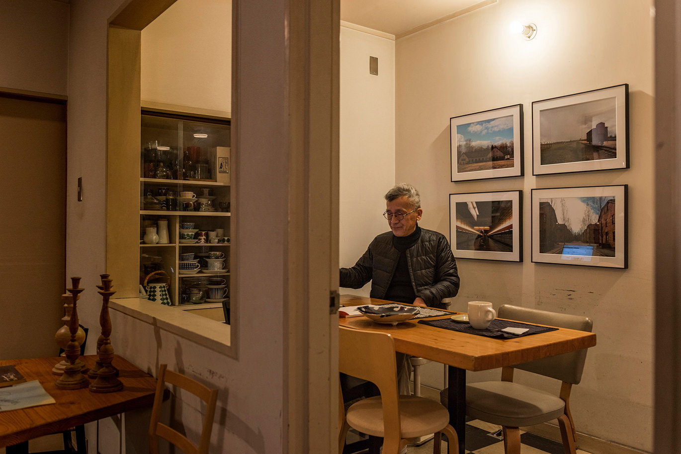 カフェで過ごす男性と壁に飾られたWALL DECOR ミュージアム