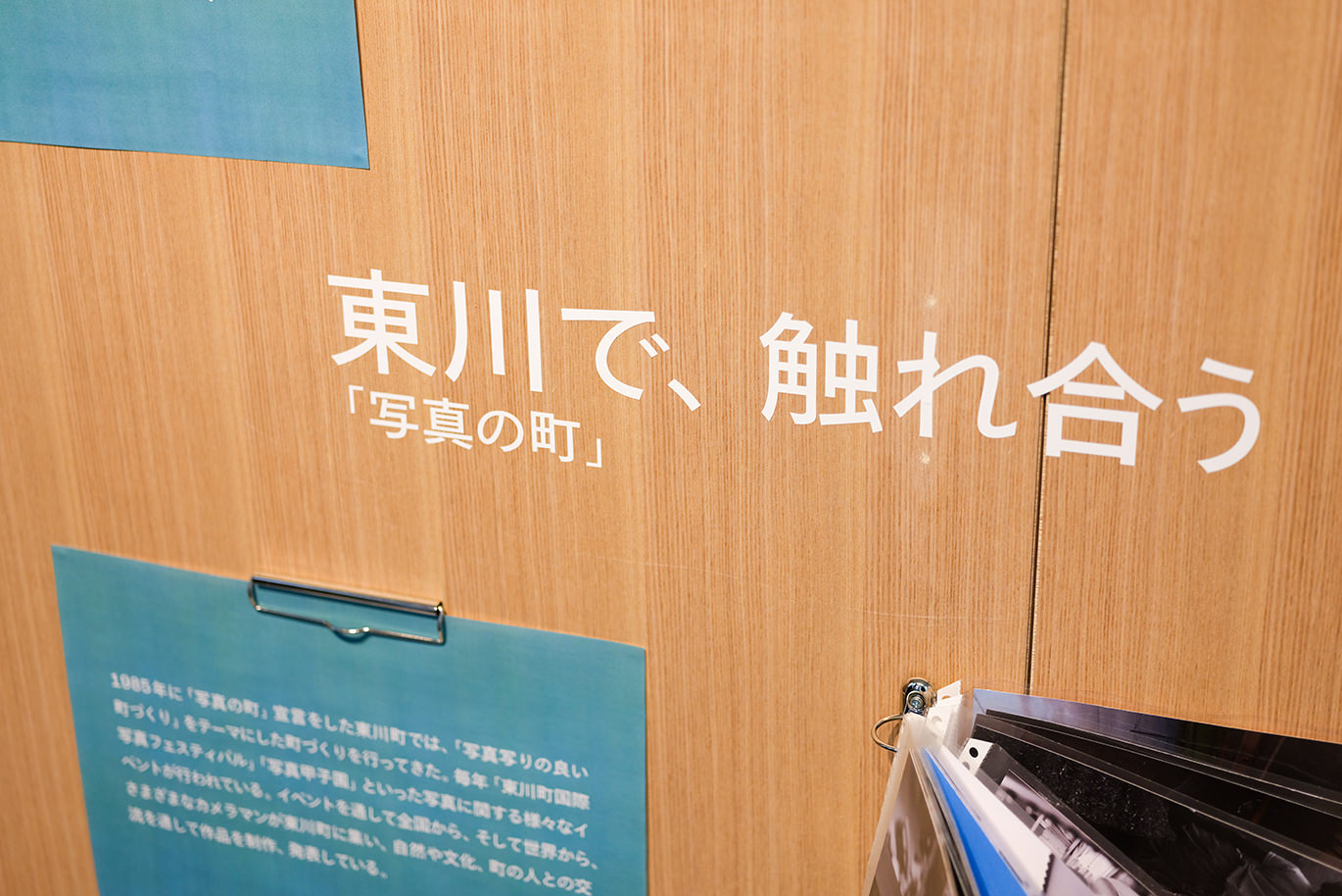 壁に記された「東川で、触れ合う」の文字と、活動を紹介する展示