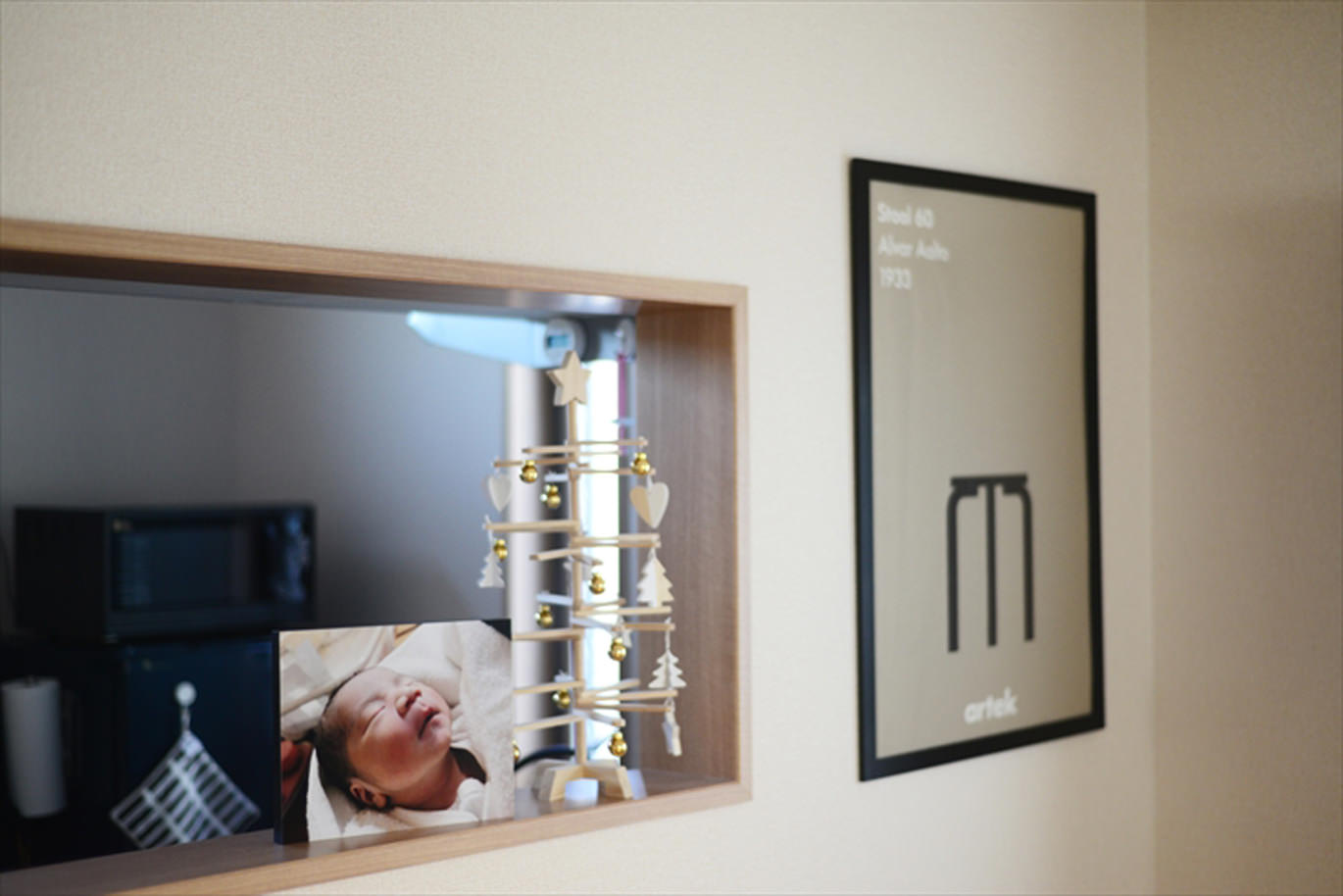 カウンターに赤ちゃんのWALL DECOR カジュアルと木のツリーを並べて飾る。