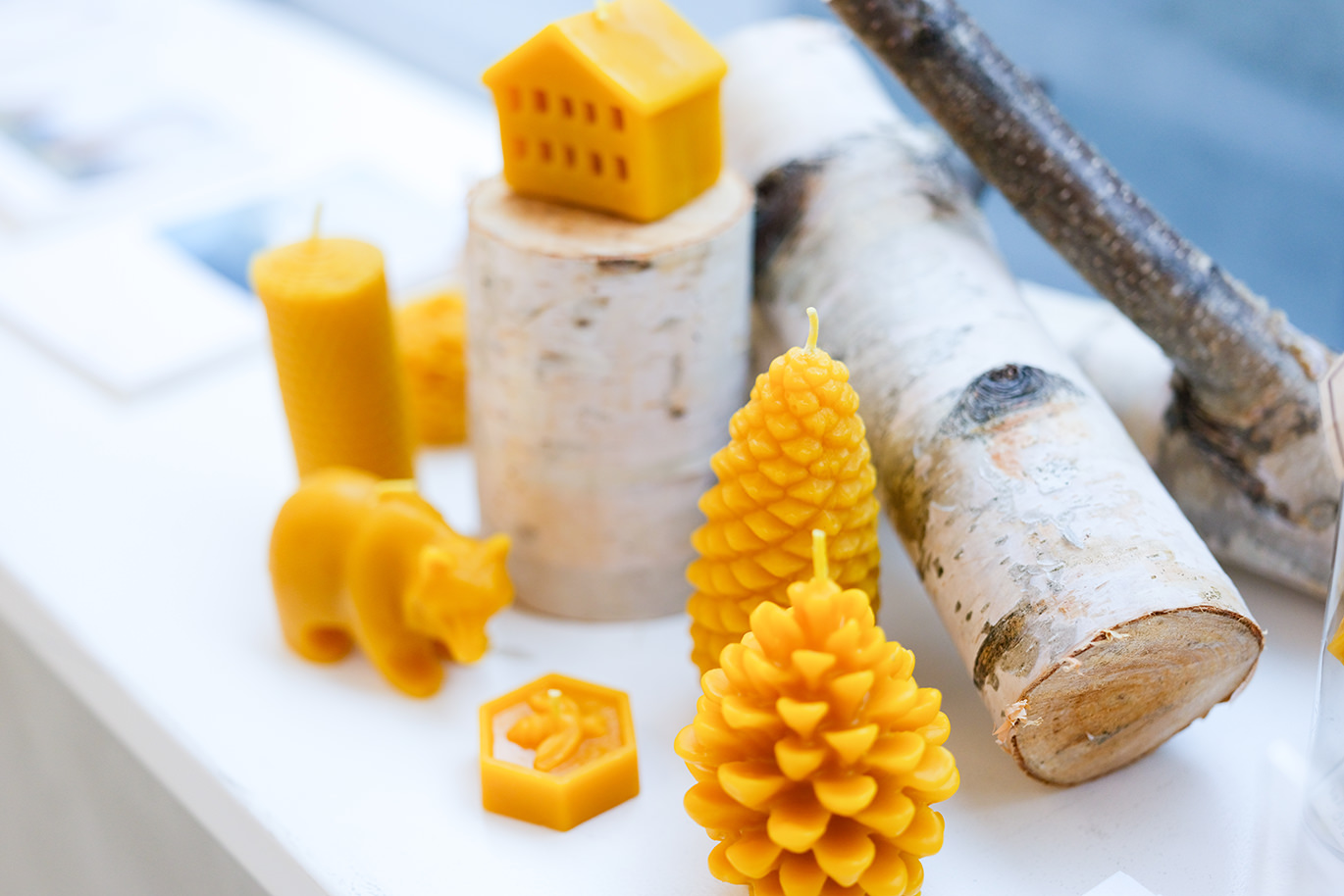 黄色いキャンドルや木のオブジェが並ぶ展示