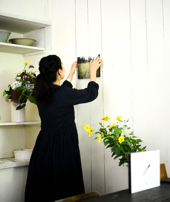 白い壁に女性がWALL DECOR ジャーナルを丁寧に飾る様子