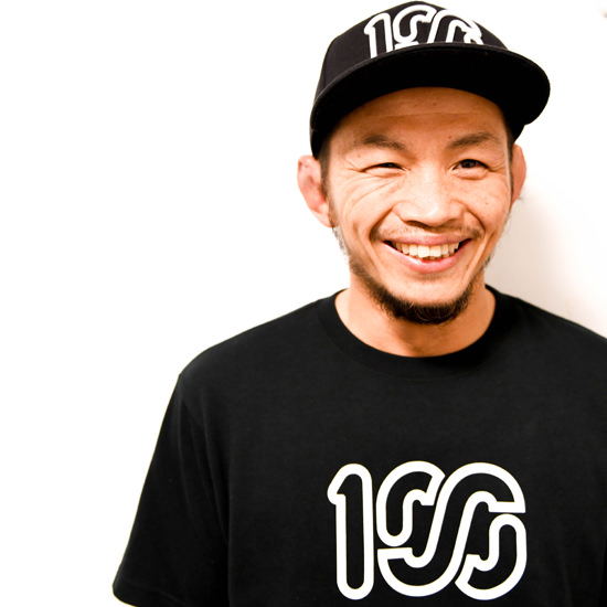 黒いキャップを被り、カメラを見つめる男性の顔写真。