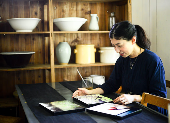 テーブルに並んだWALL DECOR カジュアルの作品を見る女性