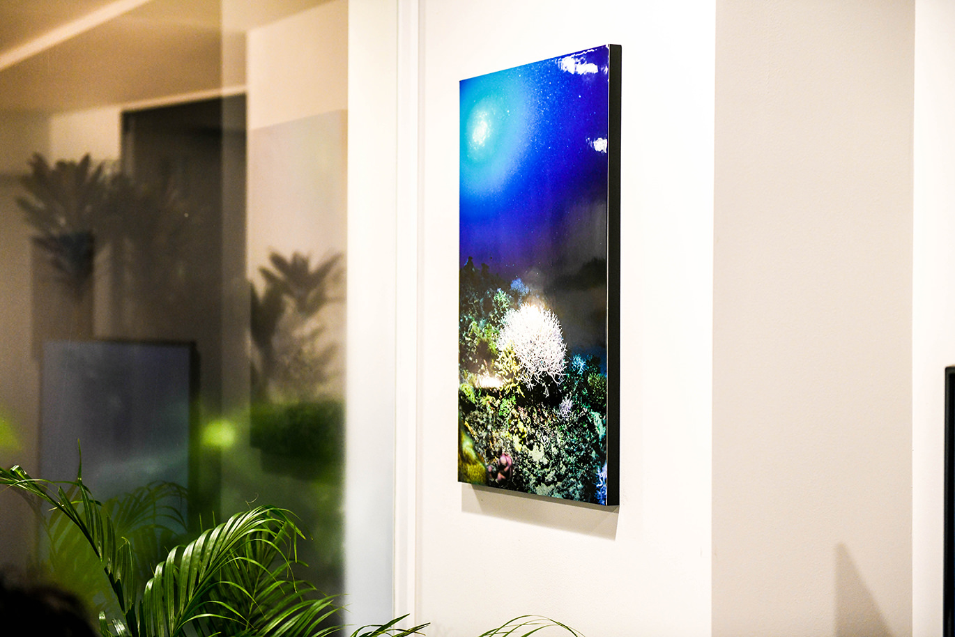 青い海と白いコーラルを描いたアートのWALL DECOR カジュアルが壁にかけられている