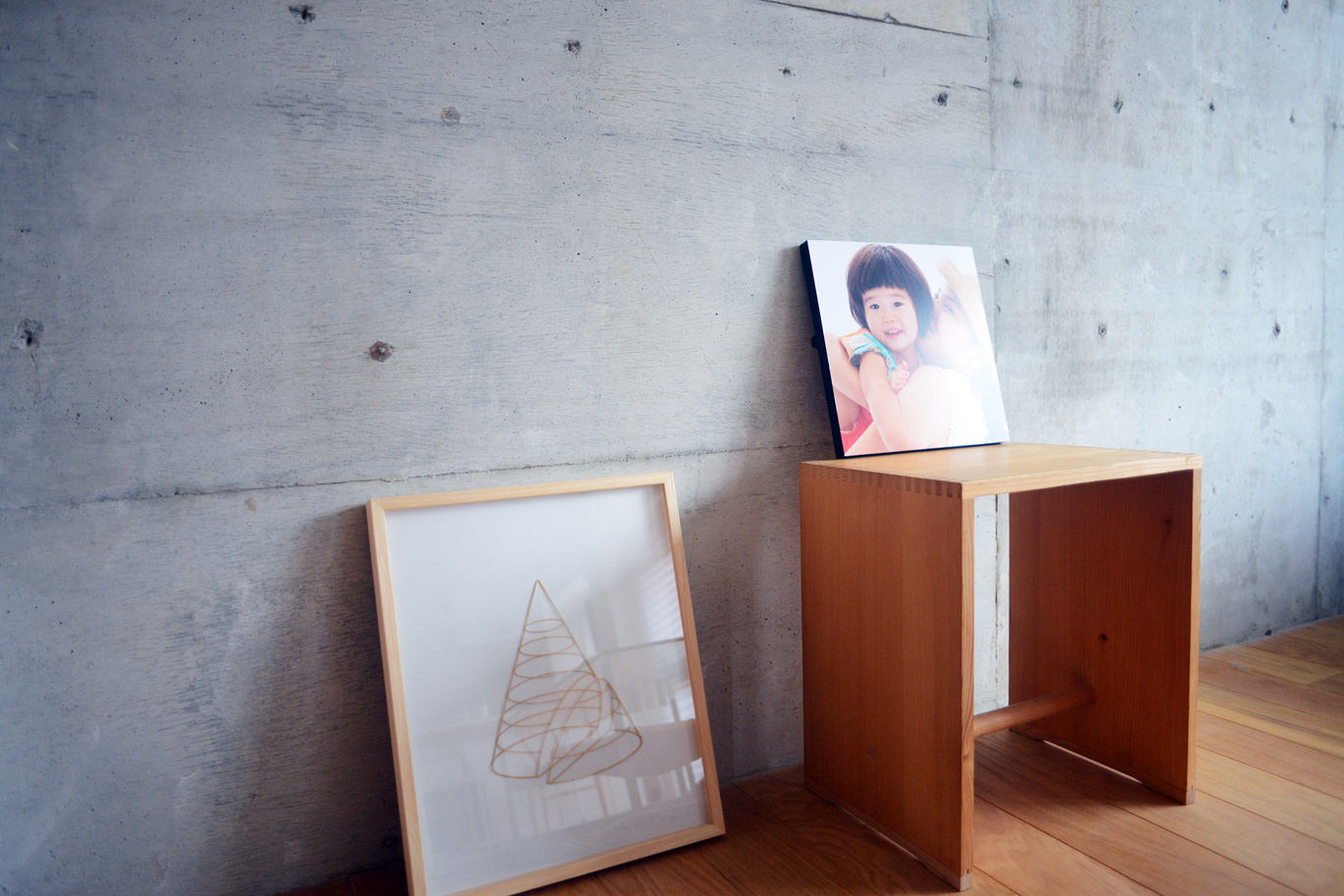 コンクリート壁を背景に椅子へ置かれたWALL DECOR カジュアル