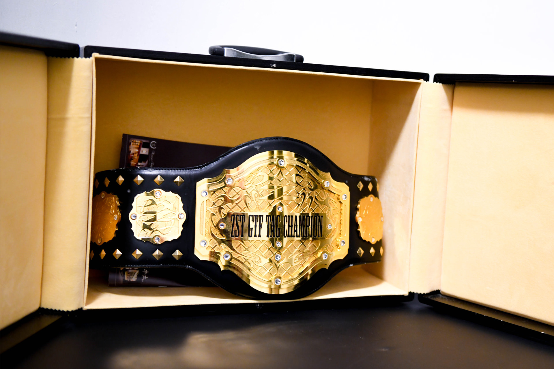 専用のケースの中でライトアップされ、黄金色に輝くボクシングのチャンピオンベルト。