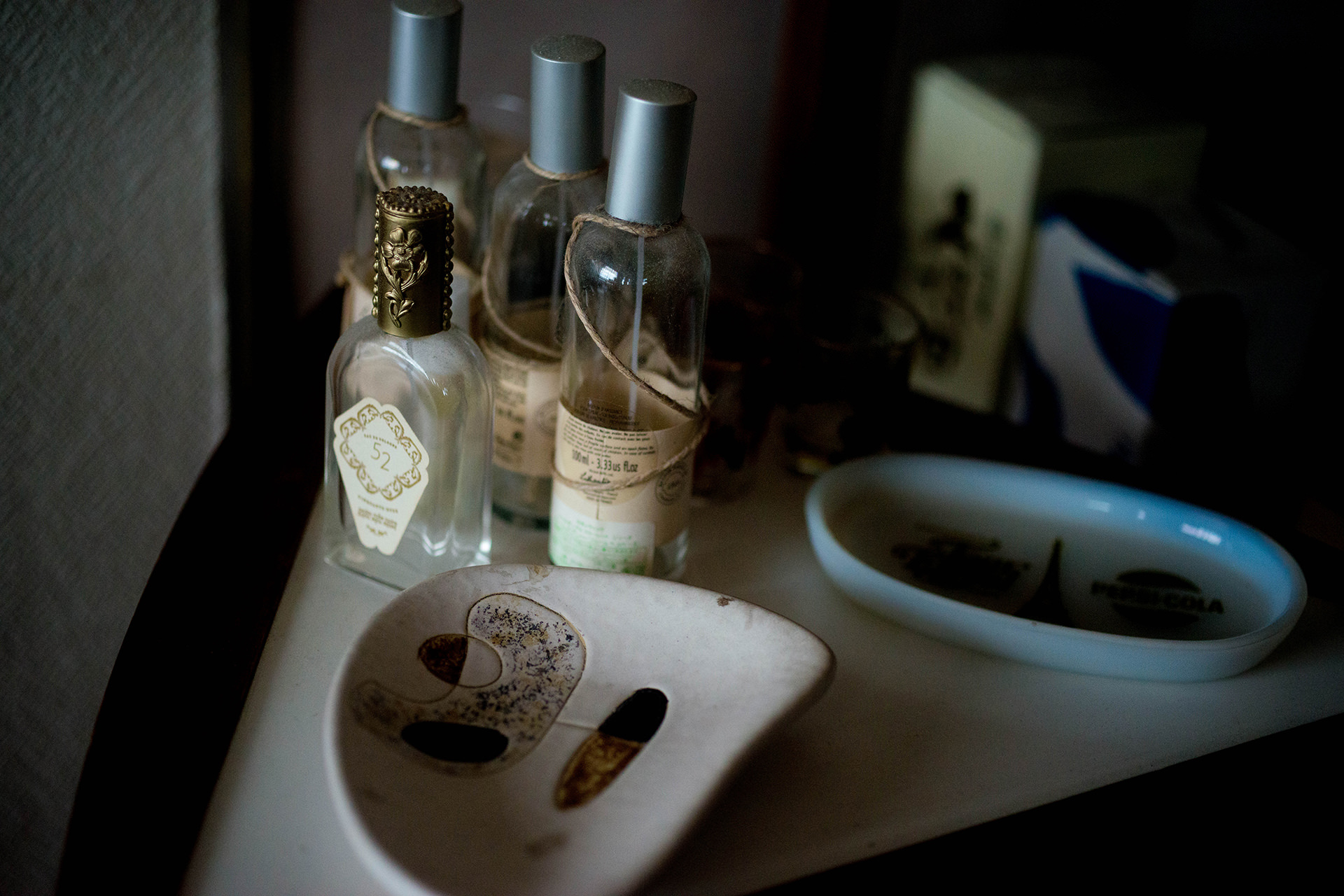 アンティーク調の香水瓶や小皿が並ぶ、落ち着いた雰囲気の卓上の風景。