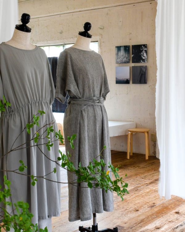 手前にグレーのワンピースを着たマネキンが並び、奥の壁に4枚の写真のWALL DECORを飾った部屋。