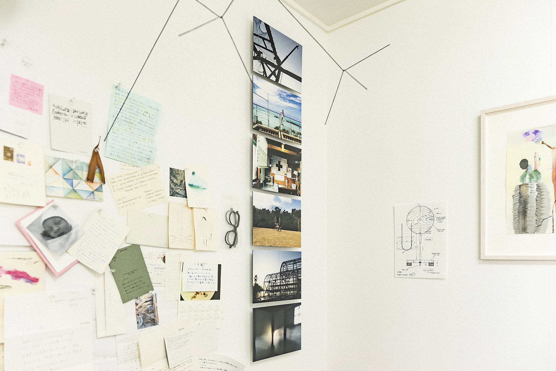 白い壁に縦一列に飾られた6枚のWALL DECOR ミュージアム。その周囲にメモやスケッチがコラージュのように配された、クリエイティブなディスプレイ風景。