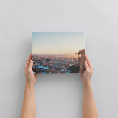 夕暮れの街並みの風景写真のWALL DECOR キャンバスを手に持つ様子