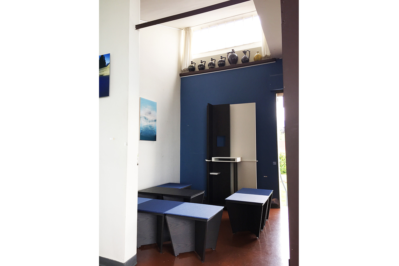 白と青の壁にアートが飾られた、モダンで落ち着いた空間