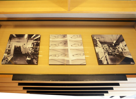 木製の棚に3枚並べて置かれた、眼鏡のフレームや工房の様子を捉えたモノクロ写真のWALL DECOR。