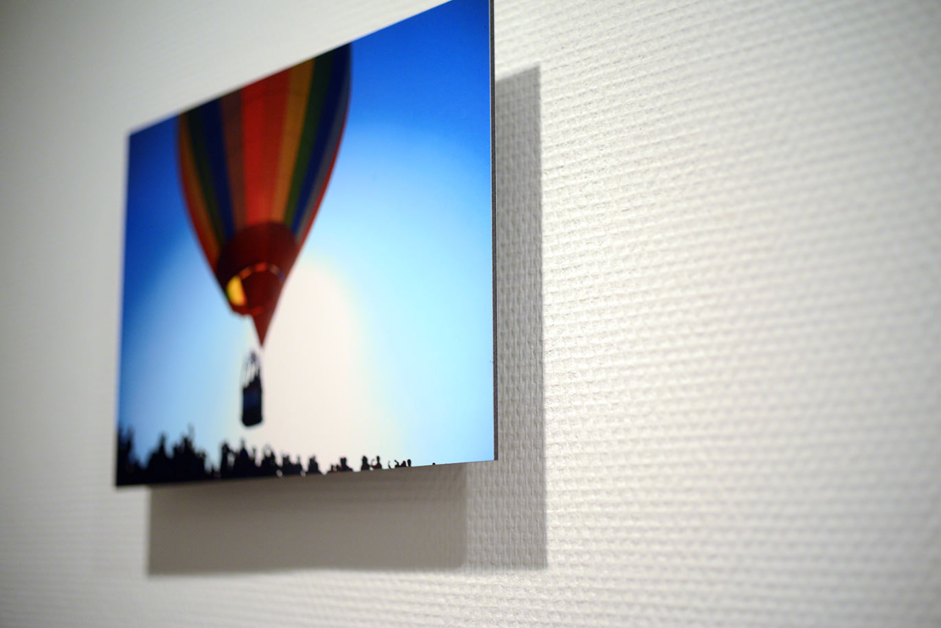 白い壁に飾られた、青空に浮かぶ気球の写真のWALL DECOR ミュージアム