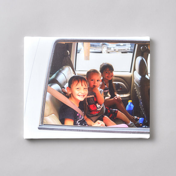車内の後部座席で笑顔を見せる3人の子供を写したWALL DECOR キャンバス