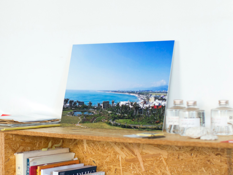 爽やかな海の風景をプリントしたウォールデコが、木製の棚に置かれている様子